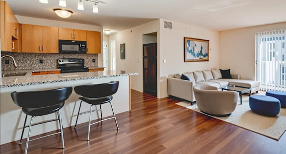 A modern kitchen with black chairs and a white countertop.