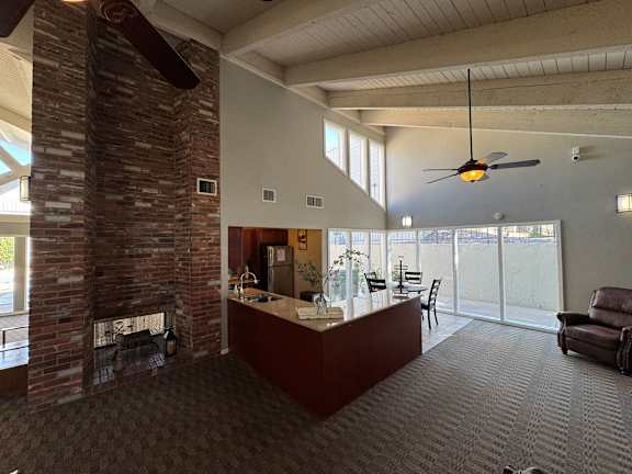 A kitchen area with dining table sits next to a fireplace.