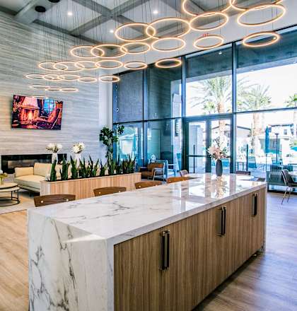 A modern office lobby with a marble counter and wooden furniture.