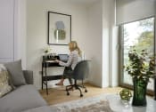 Thumbnail 6 of 7 - a woman sitting at a desk in a home office with a laptop