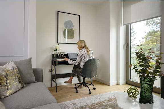 a woman sitting at a desk in a home office with a laptop