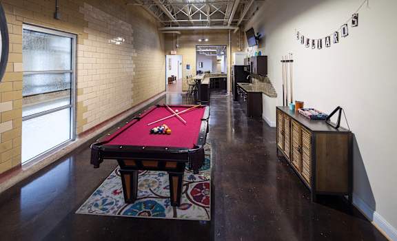 a red pool table in a room with other amenities