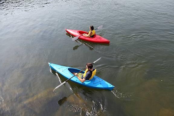 two people in kayaks on the water at Vibe Apartments at Arbour Lake, Calgary, AB