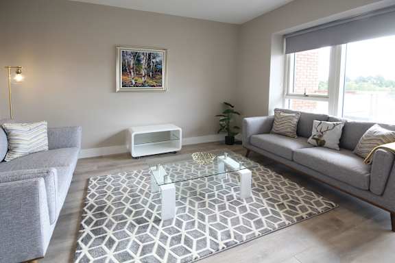 a living room with couches and a glass coffee table