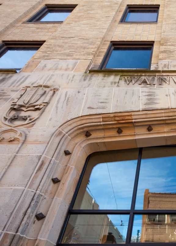 A building with a window that has a reflection of a building in it.