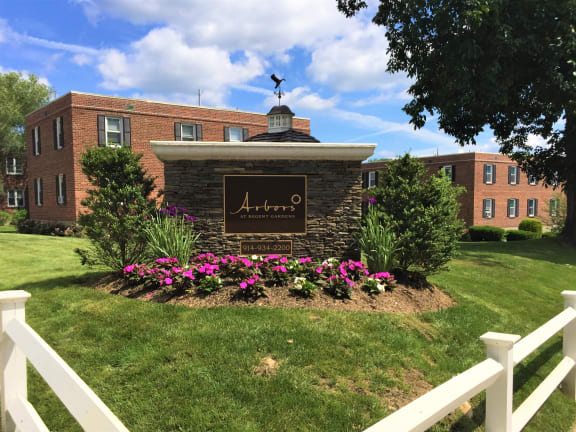 a brick building with a sign in the middle of a grassy area
