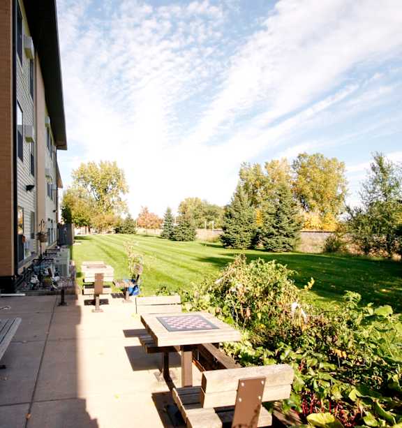 A bench is on the patio of a building.