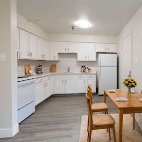 A kitchen with a table and chairs.