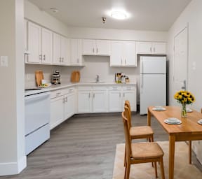 A kitchen with a table and chairs.