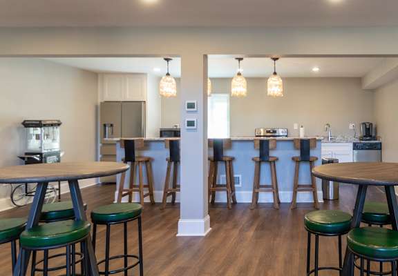 an open kitchen and living room with bar stools and tables  at Village East, Franklin, Ohio