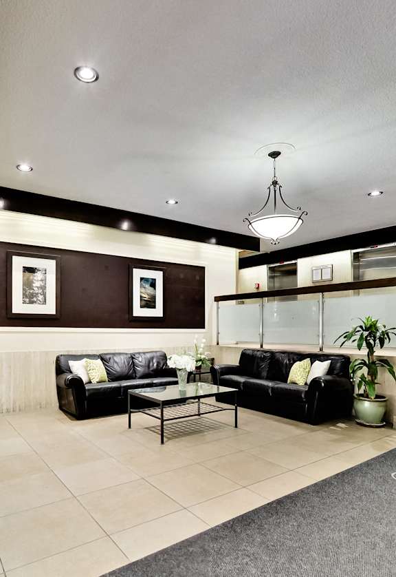 A living room with a couch, a coffee table, and a staircase.