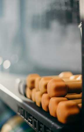 A close up of a rack of orange dumbbells.