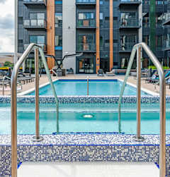 A blue and white tiled pool with a metal ladder.