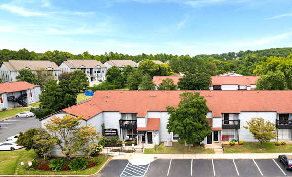 A parking lot in front of a building with a red roof.