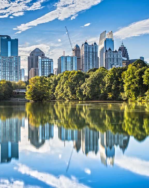 A city skyline is reflected in a body of water.