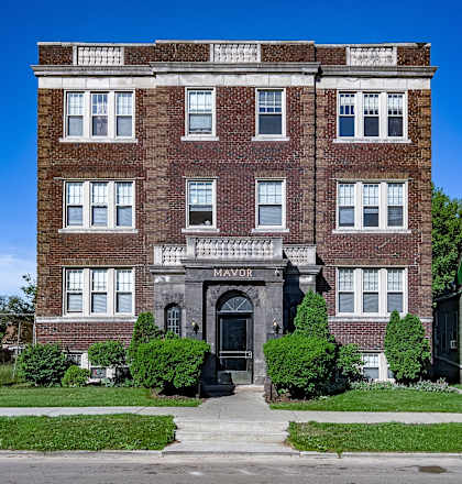 a large brick building with a sidewalk in front of it