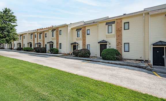a row of townhomes with a paved road in front of them