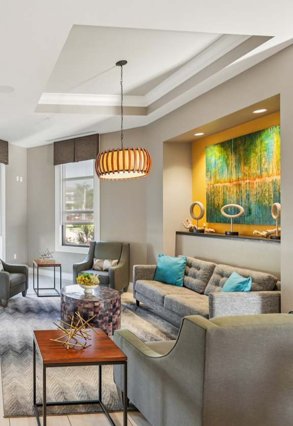 A living room with a grey couch and a brown table.