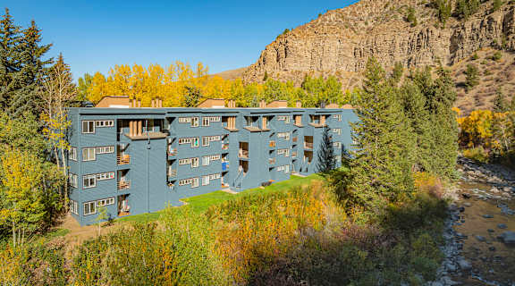 A large building with many windows is situated on a hillside.