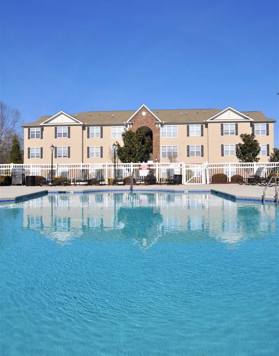 A large building with a pool in front of it.