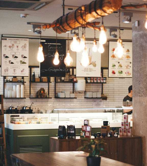 A restaurant with a wooden table and chairs in the foreground.