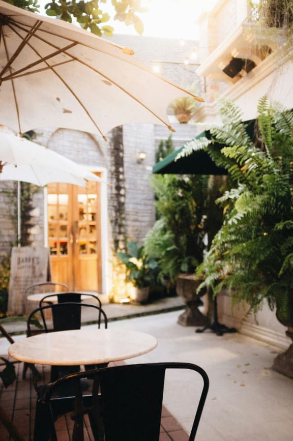 a patio with tables and umbrellas outside of a restaurant