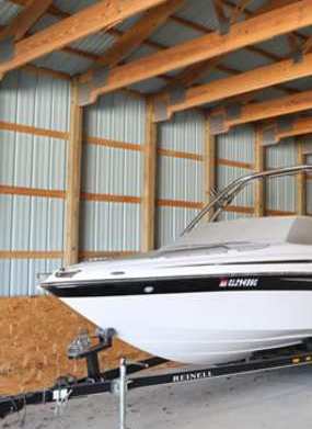 A boat is being towed by a trailer in a garage.