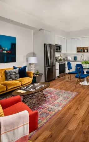 A living room with a yellow couch and a rug.