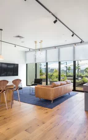 A modern living room with a wooden floor and a large window.