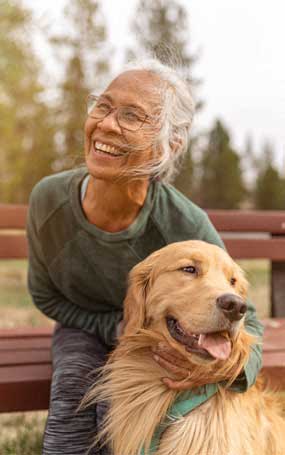 an old woman sitting on a bench with her dog
