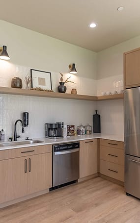 A modern kitchen with wooden cabinets and stainless steel appliances at Cascade Place Apartment Homes, Molalla, OR, 97038