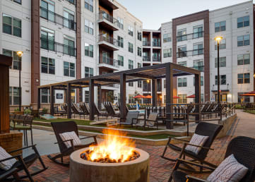 a fire pit and lounge area at the flats at big tex apartments in san antonio