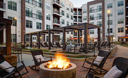 a fire pit and lounge area at the flats at big tex apartments in san antonio
