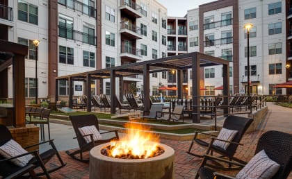 a fire pit and lounge area at the flats at big tex apartments in san antonio