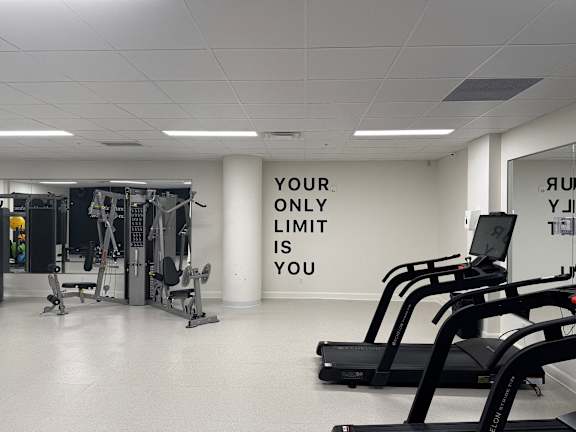 a gym with weights and a wall that says your only limit is you
