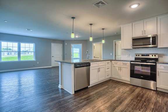 an empty kitchen with white cabinets and stainless steel appliances
