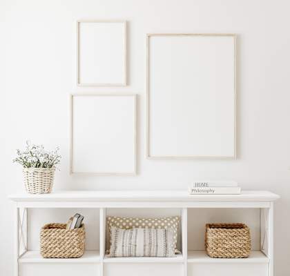 three empty picture frames above a console table in a living room
