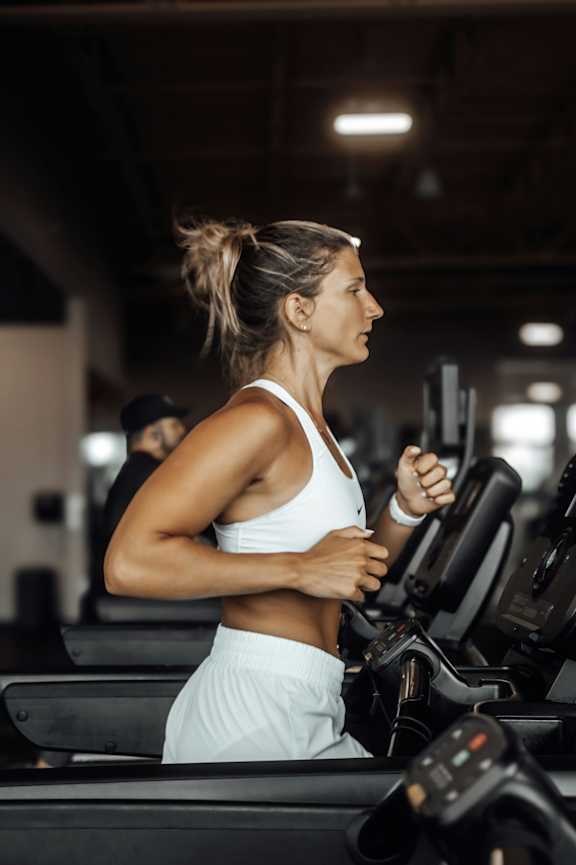 A gym with treadmills, exercise bikes and a swimming pool.