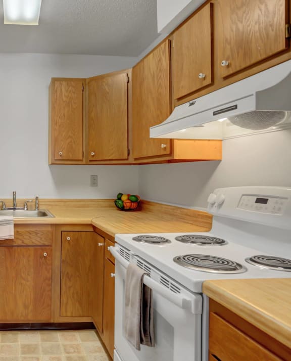 a kitchen with wooden cabinets and white appliances