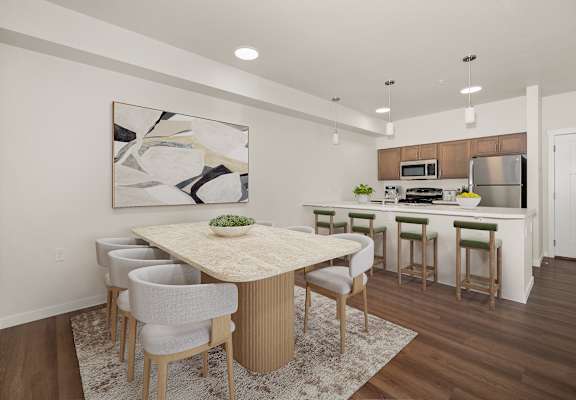 A modern kitchen with a dining table and chairs.