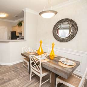 A dining room with a wooden table and chairs.