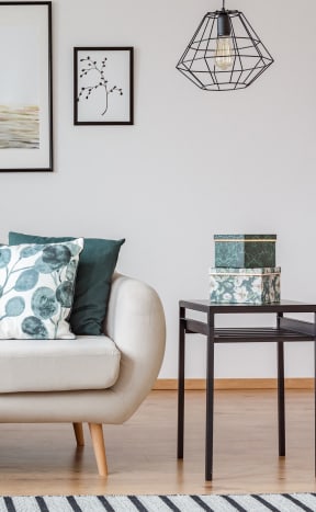 a living room with a white couch with pillows and a green blanket at Colony Townhomes, Raleigh