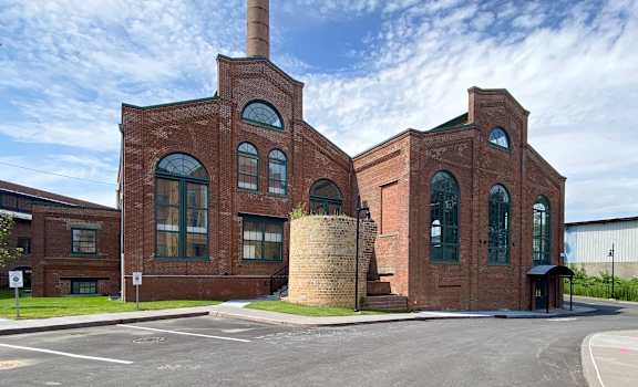 the exterior of a brick building with a smokestack