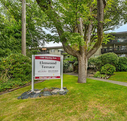 A sign for Elmwood Terrace stands in front of a building.