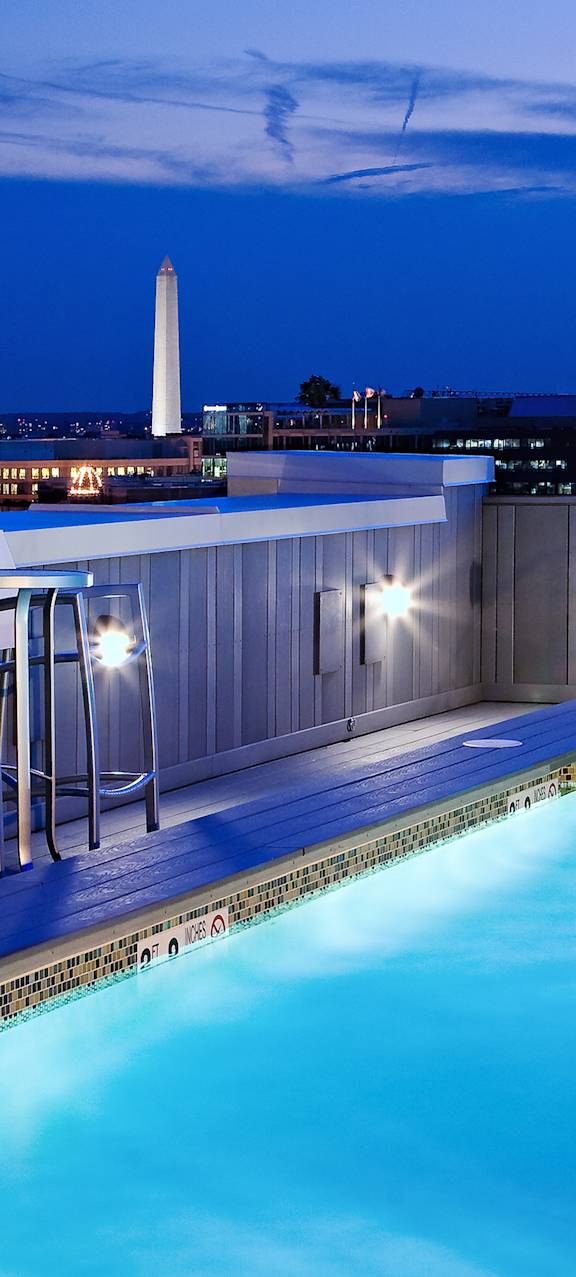 a rooftop pool with a city skyline in the background