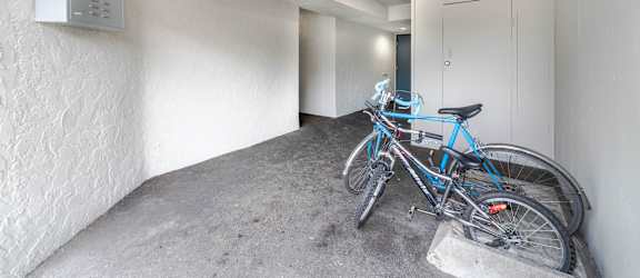 A blue bicycle is parked in a concrete nook.