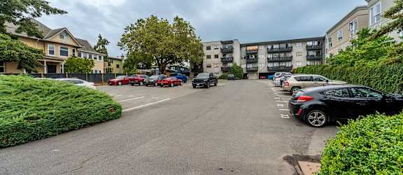 A parking lot with cars and apartment buildings in the background.