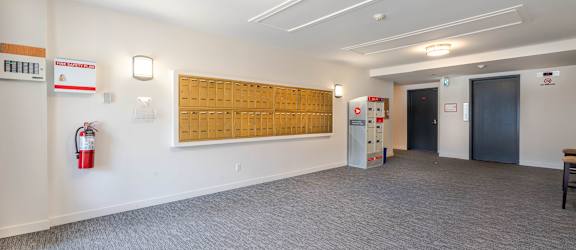 A room with a fire extinguisher on the wall and a wooden board on the wall.
