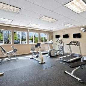 a gym with exercise equipment and windows