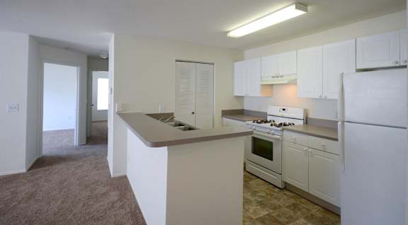 a kitchen with white cabinets and white appliances at Oak Glen Apartments, Orlando, 32808